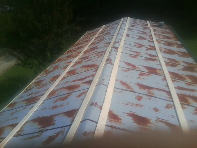 Rusted metal roof panels with new wood purlins before replacement — Storm Damage Roof Repair in Randlett by Roofing Brothers