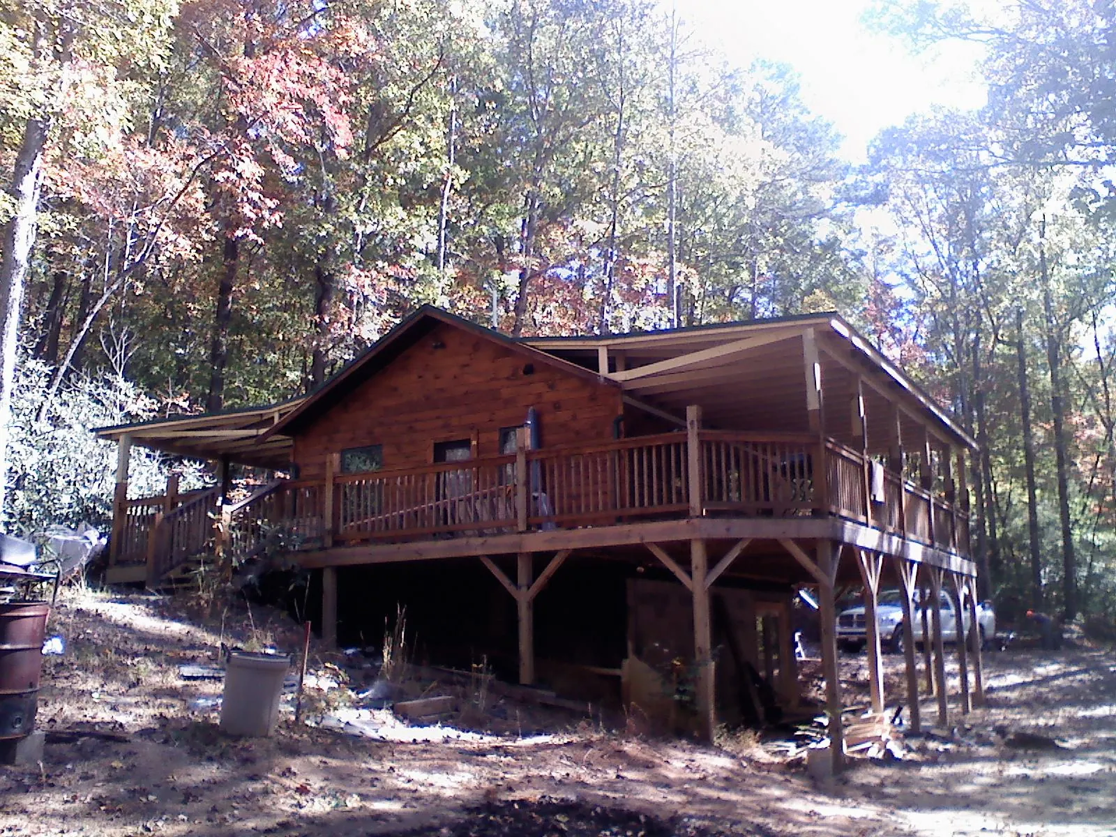Log cabin with a wraparound porch and metal roof in the fall in Randlett